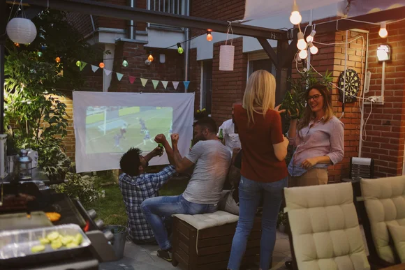 Personen bei einer Gartenparty mit Leinwand